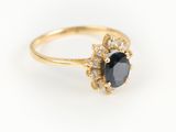 une bague en or avec une pierre noire entourée de diamants blancs