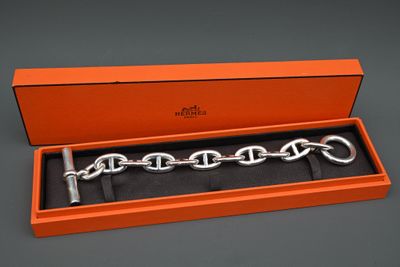 une boîte orange contenant un bracelet à chaîne argentée