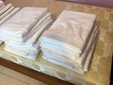 a lot of folded towels sitting on a bed