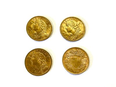 quatre types différents de pièces d'or reposant sur une surface blanche
