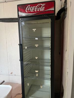 une glacière à Coca-Cola vide dans un coin de la pièce