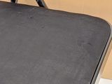 a black chair that is sitting in front of a cardboard box
