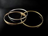 three gold and silver rings on a black background