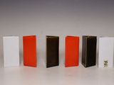 four different colors of books lined up in a row on a white surface