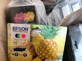 a cardboard box with a pineapple and a carton of epson ink