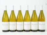 six bouteilles de vin blanc sont alignées