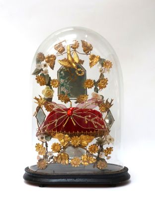 a glass dome with a red cushion inside of it