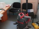 une pièce équipée d'un bureau, d'une chaise et d'un aspirateur