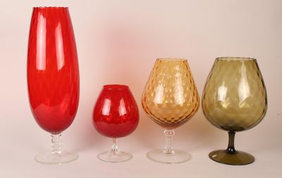 four different colored glass vases sitting next to each other