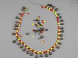 un collier orné de clochettes et de perles sur un fond gris