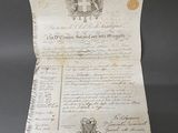 un vieux document sur lequel figure une croix, posé sur une table