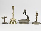 plusieurs types de bougies et de bougeoirs posés sur une surface blanche