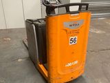 un chariot élévateur orange garé au milieu du sol d'un entrepôt