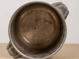 a metal cup sitting on top of a wooden table