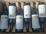 several bottles of wine are in a cardboard box on a table