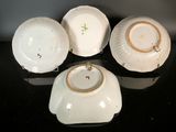 three white porcelain bowls with gold rims sitting on a black surface
