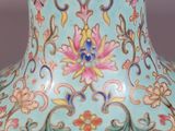 a blue vase with flowers on it sitting on a table