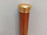 a wooden baseball bat with a gold cap on top of it