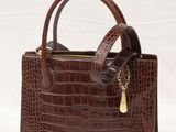 a brown crocodile skin handbag with a gold chain