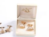 pair of gold cufflinks in a box with a pair of silver cufflinks in the box