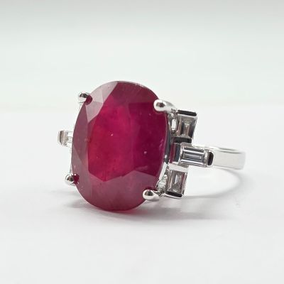 un gros plan d'une bague ornée d'une pierre rouge sur un fond blanc