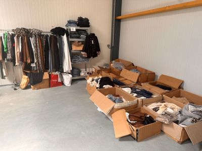 de nombreuses boîtes de vêtements dans une pièce où se trouve un portant