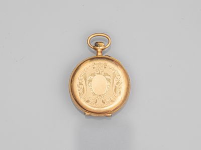 gros plan d'une montre de poche en or sur une surface blanche