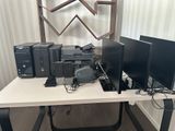 un bureau équipé de deux écrans, d'un clavier, d'une souris et d'une imprimante