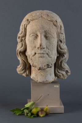 une photo d'une statue de Jésus avec une feuille par terre