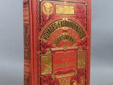 un vieux livre rouge orné de lettres dorées, posé sur une table