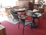 tables and chairs in a room with a red carpet and a red rug