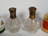 trois petits flacons de parfum en verre sont alignés sur une surface blanche