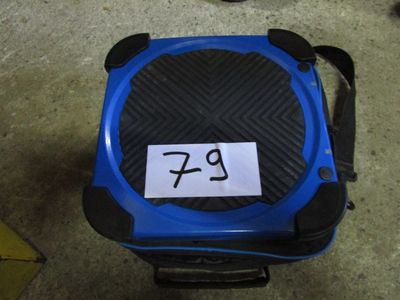 une valise bleue avec un autocollant, posée par terre