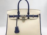 un gros plan d'un sac à main blanc et bleu posé sur une table