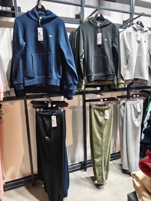 beaucoup de vêtements suspendus à une étagère dans un magasin