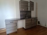 a kitchen with a sink, cabinets, and a refrigerator in it