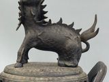 bronze statue of a goat with horns on top of a metal container