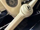 dashboard of a classic car with a steering wheel and a clock
