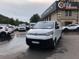 une camionnette blanche garée devant un bâtiment dans un parking