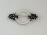 a picture of a white brooch with a blue and white design