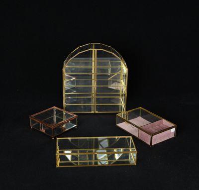 trois petites boîtes en verre avec des miroirs, posées sur une surface noire