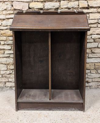 an old wooden bookcase with two open doors and a stone wall in the background
