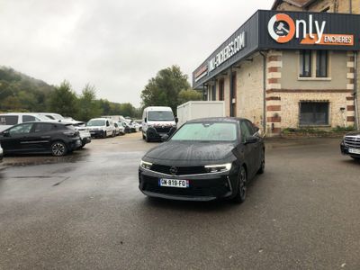 des voitures garées sur un parking devant un immeuble où une pancarte indique « réservés aux motos »