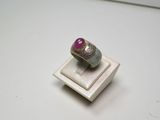 bague en argent ornée d'une pierre rose sur un fond blanc