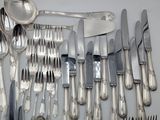 a lot of silverware on a table with spoons and knives