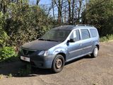 une camionnette bleue garée sur un parking près de quelques arbres