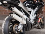 a black motorcycle parked in front of a brick wall