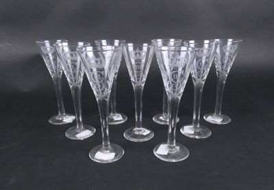 six verres à vin transparents sont alignés sur une surface noire