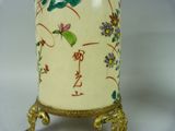 a white vase with a gold base and a floral design on it