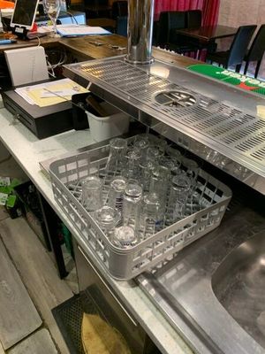 une cuisine équipée d'un évier, d'un lave-vaisselle et d'autres éléments posés sur le plan de travail